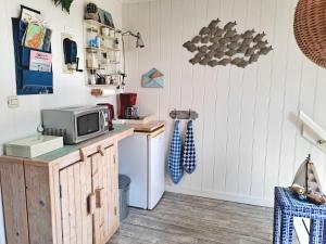 a kitchen with a microwave and a small refrigerator at Unia's Verhuur in Zoutelande