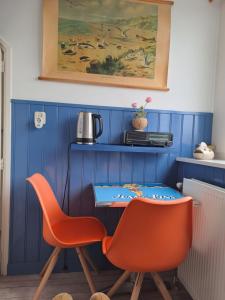 a blue room with two chairs and a table at Unia's Verhuur in Zoutelande