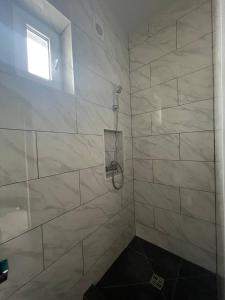 y baño con ducha de azulejos blancos. en VIP HOTEL ZATOKA, en Zatoka