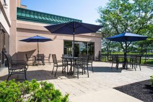 a patio with tables and chairs with umbrellas at Hampton Inn Buffalo-South/I-90 in West Seneca