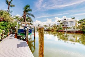 a dock with a house in the background on a river at Dixie Beach Delight in Sanibel