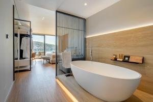 a bathroom with a large white tub in a room at Yacht Premium Hotel in Sarandë