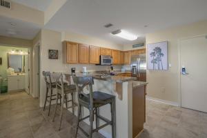 a kitchen with a island with bar stools at Navy Cove Harbor 1205 by Vacation Homes Collection in Fort Morgan