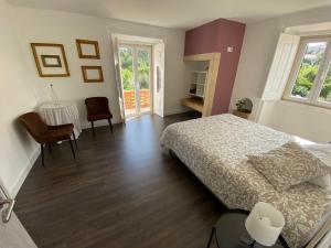 a bedroom with a bed and a table and chairs at Casa do Prado in Tomar