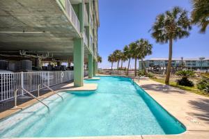 a swimming pool with palm trees and a building at Navy Cove Harbor 1205 by Vacation Homes Collection in Fort Morgan