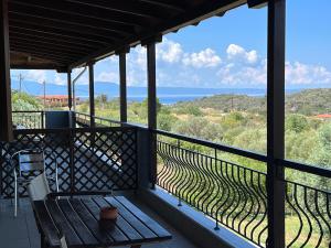 a balcony with a bench and a view of the ocean at Athos Bay Villa in Ammouliani