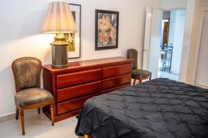 a bedroom with a bed and a dresser and two chairs at Casa Lana Central in Ajijic
