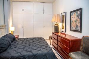 a bedroom with a bed and a desk and cabinets at Casa Lana Central in Ajijic