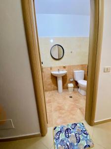 uma casa de banho com um lavatório e um WC em Eden Home em Durrës