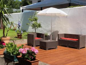 une terrasse en bois avec deux chaises et un parasol dans l'établissement Ca' Bianca Relax Apartment, sur le Lido de Venise