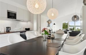 uma cozinha e sala de jantar com mesa e cadeiras em Stunning Home In Holbk With 3 Bedrooms, Sauna And Wifi em Kisserup