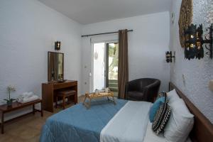 a bedroom with a bed and a chair and a mirror at CASA MIKELE by Sarikas Anthony Quinn Beach Faliraki - Ladikos Garden in Faliraki