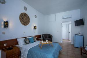 a bedroom with a bed with a table and a chair at CASA MIKELE by Sarikas - SEA SIDE SUITES and STUDIOS -adults only in Faliraki +112 photos