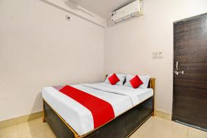 1 dormitorio con 1 cama con manta roja y blanca en OYO Flagship 81047 Hotel Dream Inn, en Gamhāria