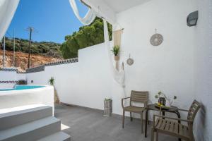 a patio with a table and chairs and a pool at CASA MIKELE by Sarikas - SEA SIDE SUITES and STUDIOS -adults only in Faliraki