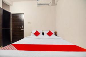 a bedroom with a bed with red pillows at OYO Flagship 81047 Hotel Dream Inn in Gamhāria