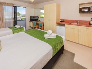 Habitación de hotel con 2 camas y cocina en Bella Vista Motel Greymouth, en Greymouth