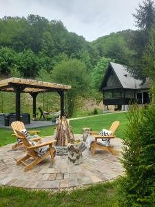 a patio with two chairs and a fire pit at Căsuța cu doi brazi in Baia Mare