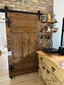 a large wooden door in a kitchen with a counter at Căsuța cu doi brazi in Baia Mare