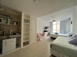 Un dormitorio con 2 camas y una mesa en una habitación en Clover Apartment Studio en Buenos Aires