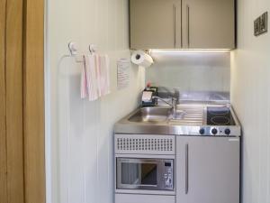 a small kitchen with a sink and a refrigerator at Alstroemeria in Evesham