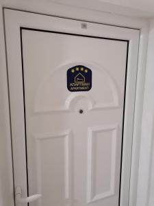 ein Schild an der Tür einer weißen Tür in der Unterkunft JM Apartman in Čačak