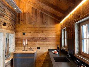 a kitchen with wooden walls and a sink and a counter at DOLOMITISCAPE CHALET in Badia