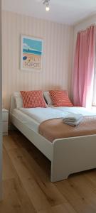 ソポトにあるApartament nad morzemのベッドルーム1室(ピンクのカーテンが付いた大型ベッド1台付)