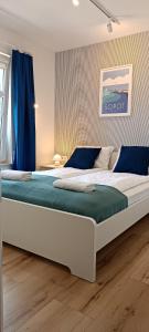 ソポトにあるApartament nad morzemのベッドルーム(青い枕の大きな白いベッド付)