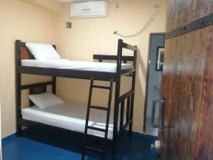 Cette chambre comprend 2 lits superposés et une porte. dans l'établissement Hotel Gavas Amazonas, à Leticia