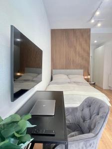 a bedroom with a bed and a table with a laptop at Modernes Apartment im Zentrum von Karlsruhe in Karlsruhe
