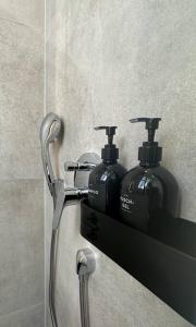 a shelf with two soap dispensers on a wall at Modernes Apartment im Zentrum von Karlsruhe in Karlsruhe