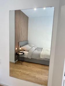a bedroom with a bed in a room with a mirror at Modernes Apartment im Zentrum von Karlsruhe in Karlsruhe