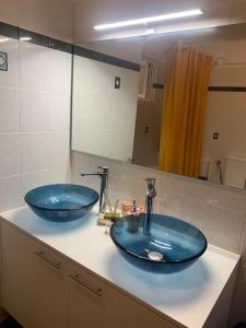 a bathroom with two blue sinks and a mirror at Apartment Aura in Argostoli +6 photos