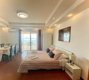 a bedroom with a bed and a table and a balcony at Apartments Marnic in Mlini