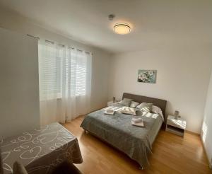 a bedroom with a bed and a large window at Apartments Marnic in Mlini