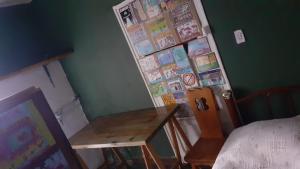 a room with a table and a wall with drawings at Dormitorio Privado in La Cieneguita