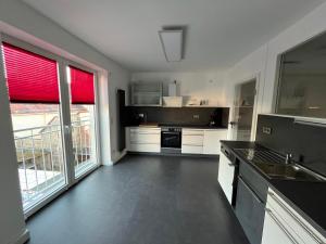 a kitchen with white cabinets and a large window at Ferienwohnung Richard in Zittau