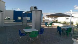 a patio with tables and chairs and an umbrella at Studio du Lagon de Hammamet in Nabeul