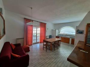 uma sala de estar com um sofá vermelho e uma mesa em Ischia Villa Casa Caruso con piscina 6 posti letto em Ischia
