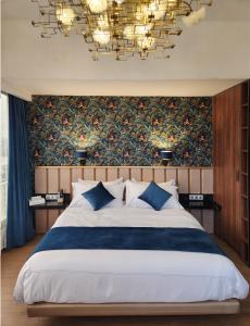 a bedroom with a large bed and a chandelier at Appartements Lamblin in Abidjan