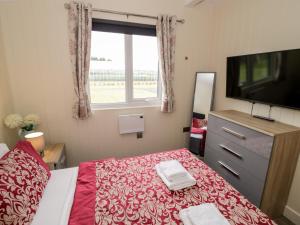 a bedroom with a bed and a flat screen tv at Cotswold View 4 in Evesham