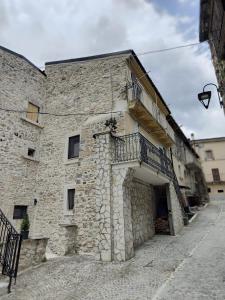 a stone building with a balcony on the side of it at Casa rustica in Cansano