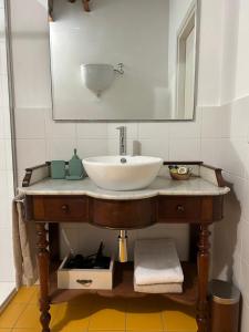 y baño con lavabo y espejo. en OlioeAlloro nel Borgo, en Campiglia Marittima