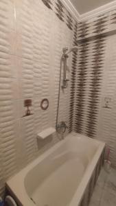 uma banheira branca numa casa de banho branca em شقة مفروشة بالكامل بالإسكندرية تانى صف بحر em Alexandria