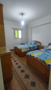 um quarto com 2 camas e uma janela em شقة مفروشة بالكامل بالإسكندرية تانى صف بحر em Alexandria