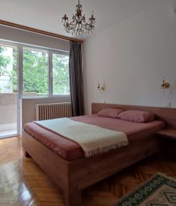 a bedroom with a large bed and a chandelier at Bohemian Home in Skopje