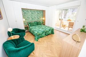 una camera con un letto verde e due sedie di Fabuleux Studio a Beausoleil