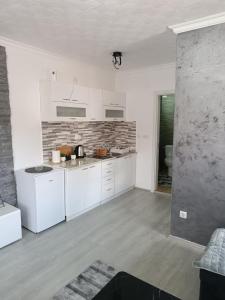 a kitchen with white cabinets and a brick wall at ATOS in Belgrade