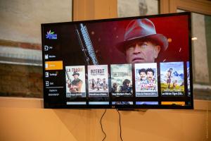 a flat screen tv with a man in a hat on it at CosyRouen Bali Spa Hamman in Rouen